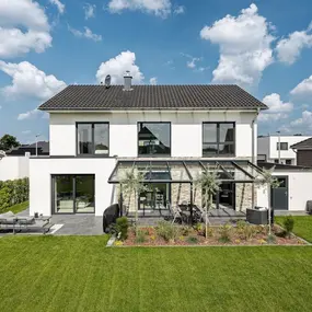 Modernes Einfamilienhaus mit Wintergarten, großer Terrasse und gepflegtem Garten.