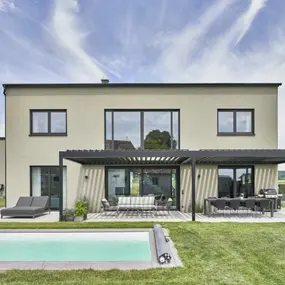 Modernes Einfamilienhaus mit Flachdach, Terrasse und Pool im gepflegten Garten.